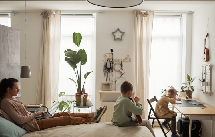 family at rest. woman on bed two children in room with her
